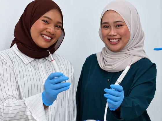 Dental surgery assistants holding airflow polishing handpieces